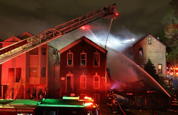 Firefighters work to extinguish an extra-alarm fire that damaged at least three structures, completely destroying one building, in the 1300 block of West 16th Street Wednesday, April 17, 2024, in Chicago. (John J. Kim/Chicago Tribune)