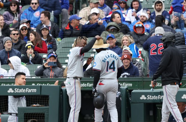 Marlins designated hitter Bryan De La Cruz (14) receives a hat by left fielder Nick Gordon (1) after hitting a two-run home run in the ninth inning against the Cubs at Wrigley Field on April 20, 2024, in Chicago. The home run resulted in a 3-2 Marlins win. (John J. Kim/Chicago Tribune)