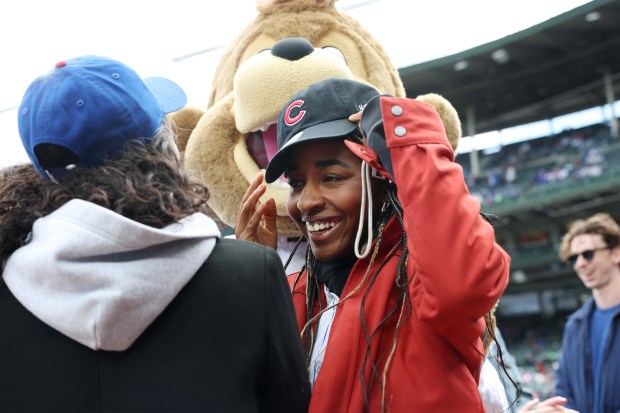 Actor Ayo Edebiri of the show, "The Bear," adjusts her cap after hugging Cubs mascot Clark before a game between the Cubs and Marlins at Wrigley Field on April 20, 2024, in Chicago. (John J. Kim/Chicago Tribune)
