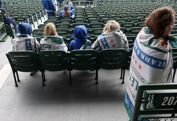 Fans cover themselves with Cubs fleece blankets given to people entering Wrigley Field before a game against the Marlins on April 20, 2024, in Chicago. (John J. Kim/Chicago Tribune)