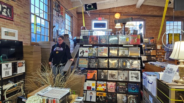 April Zamirowski of Montgomery enters Kiss the Sky record shop in Batavia Saturday morning, the first of more than 200 people who participated in a lottery to get into the store to buy limited editions records in celebration of Record Store Day. (David Sharos / For The Beacon-News)