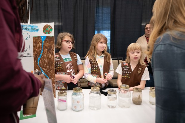 Girl Scout troop 35650 members, from left, Sabrina Bell, 8, Claire Howell, 8, and Nora O'Dea, 8, stand near jars demonstrating drain-unfriendly materials as they speak with visitors from their booth at the 16th annual Recycling and Waste Reduction District of Porter County Earth Day Program on Saturday, April 20, 2024. (Kyle Telechan/for the Post-Tribune)