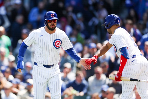 Chicago Cubs third base Christopher Morel (5) high-fives outfielder Mike Tauchman (40) after Tauchman scored a run during the second inning against the Miami Marlins at Wrigley Field on April 21, 2024. (Eileen T. Meslar/Chicago Tribune)