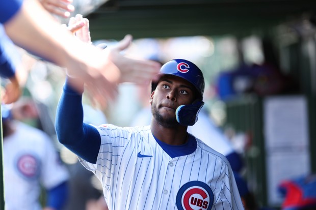 Chicago Cubs outfielder Alexander Canario (4) gets high-fives in the dugout after scoring a run during the fourth inning against the Miami Marlins at Wrigley Field on April 21, 2024. (Eileen T. Meslar/Chicago Tribune)