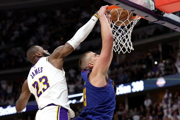 Nikola Jokic of the Denver Nuggets dunks on LeBron James of the Los Angeles Lakers in Game 1 of the Western Conference first-round playoff on Saturday. (Photo by Matthew Stockman/Getty Images)