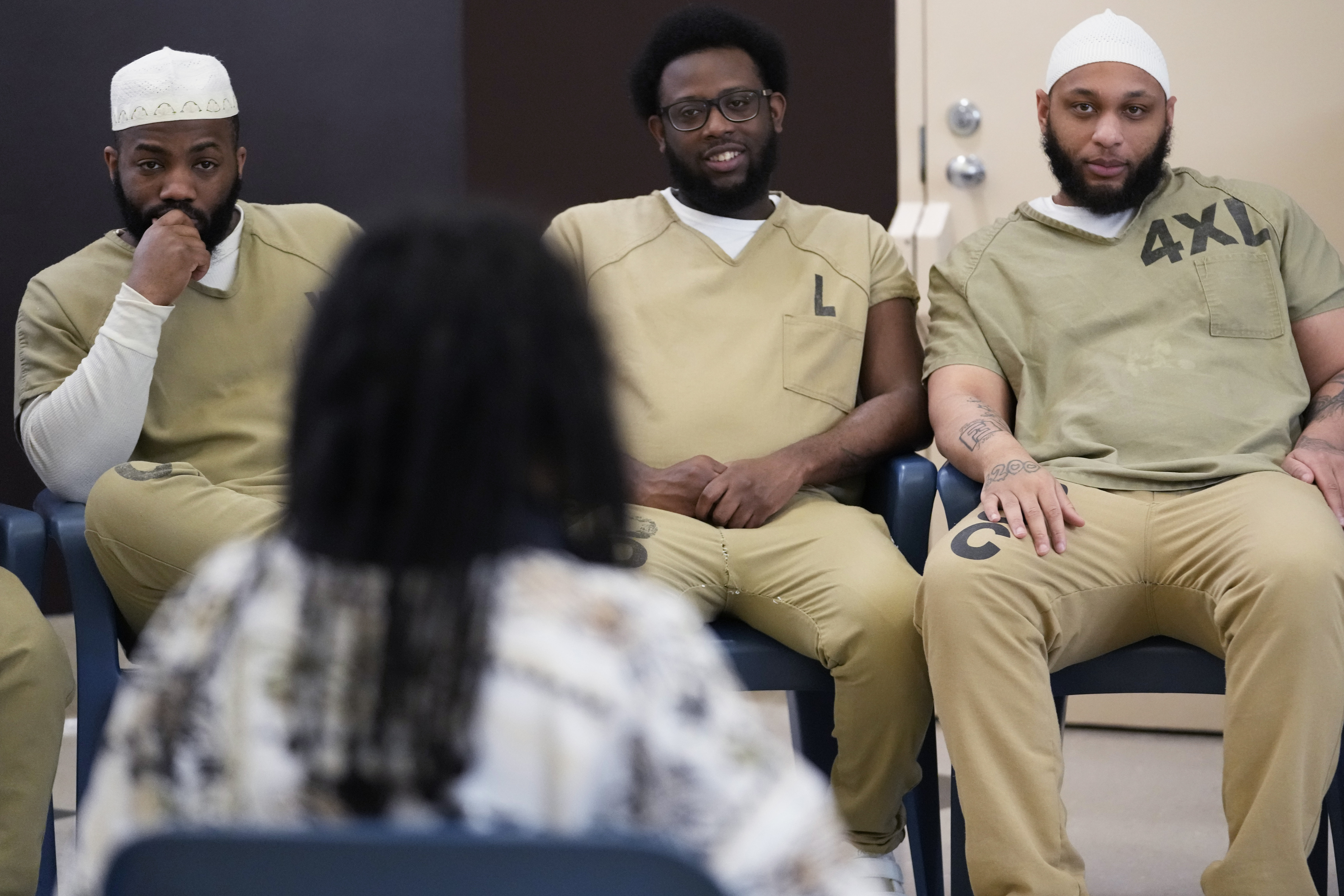 Detainees listen to Seven Clark during a book club at...