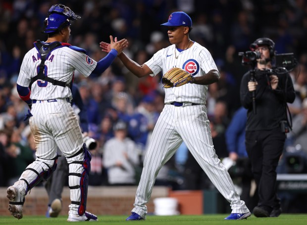 Chicago Cubs catcher Miguel Amaya (9) and relief pitcher Yency Almonte (25) celebrate after closing out the Houston Astros in the ninth inning of a game at Wrigley Field in Chicago on April 23, 2024. (Chris Sweda/Chicago Tribune)