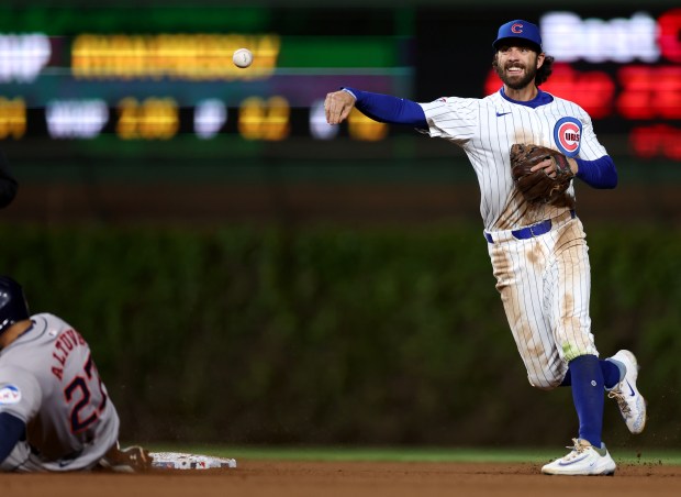 Chicago Cubs shortstop Dansby Swanson (7) throws to first base after forcing out Houston Astros baserunner Jose Altuve (27) at second base in the 8th inning of a game at Wrigley Field in Chicago on April 23, 2024. (Chris Sweda/Chicago Tribune)