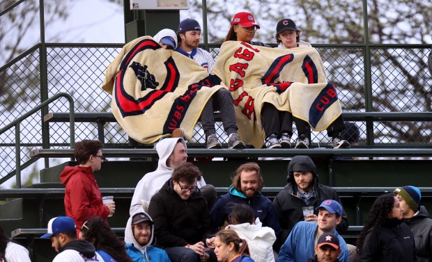 Chicago Cubs fans keep warm under blankets in the left field bleachers in the first inning of a game between the Cubs and the Houston Astros at Wrigley Field in Chicago on April 23, 2024. (Chris Sweda/Chicago Tribune)