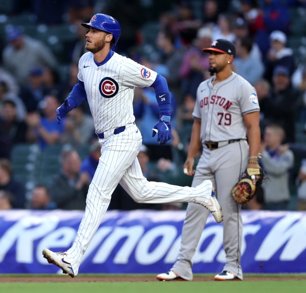 Chicago Cubs outfielder Cody Bellinger (24) passes by Houston Astros first baseman José Abreu (79) as Bellinger rounds the bases after hitting a 2-run home run in the first inning of a game at Wrigley Field in Chicago on April 23, 2024. (Chris Sweda/Chicago Tribune)