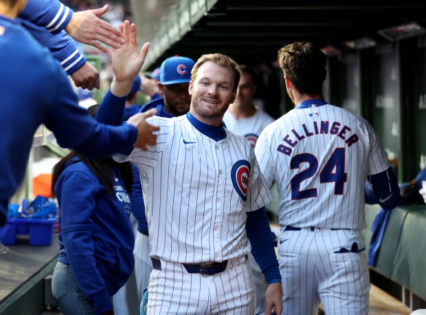 Chicago Cubs outfielder Ian Happ (8) wears a smile on his face as he is congratulated in the dugout after scoring on a 2-run home run by teammate Cody Bellinger (24) in the first inning of a game against the Houston Astros at Wrigley Field in Chicago on April 23, 2024. (Chris Sweda/Chicago Tribune)