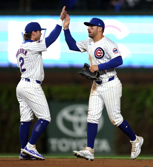Chicago Cubs second baseman Nico Hoerner (2) and outfielder Mike Tauchman (40) celebrate after a victory over the Houston Astros at Wrigley Field in Chicago on April 23, 2024. (Chris Sweda/Chicago Tribune)