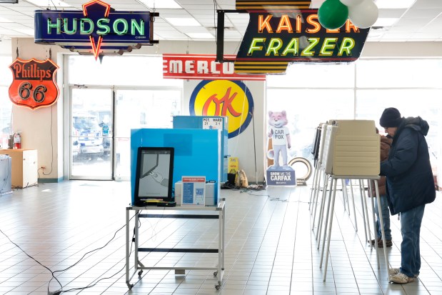 Surrounded by vintage signage and cars, Steve Langridge votes at Windy City Motors in Chicago during the Illinois primary election on March 19, 2024. (Antonio Perez/Chicago Tribune)