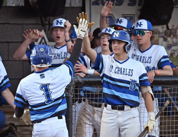 St. Charles North's Joshua Caccia (1) celebrates with his teammates after scoring on a passed ball during the 4th inning of Monday's game against St. Charles East, April 29, 2024. St. Charles North won the game, 10-1. (Brian O'Mahoney for the The Beacon-News)