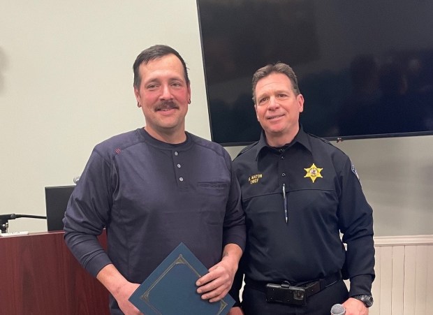 Jared Read, left, a worker at the CITGO refinery in Lemont, stands with Lemont police Chief Marc Maton after being honored by village officials for his actions that helped save a motorist who was trapped in a burning vehicle near the refinery in January. (CITGO)