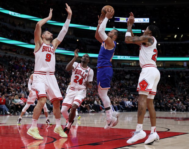 New York Knicks guard Jalen Brunson (11) goes up for a shot as Chicago Bulls center Nikola Vucevic (9) defends in the second half of a game at the United Center in Chicago on April 9, 2024. (Chris Sweda/Chicago Tribune)