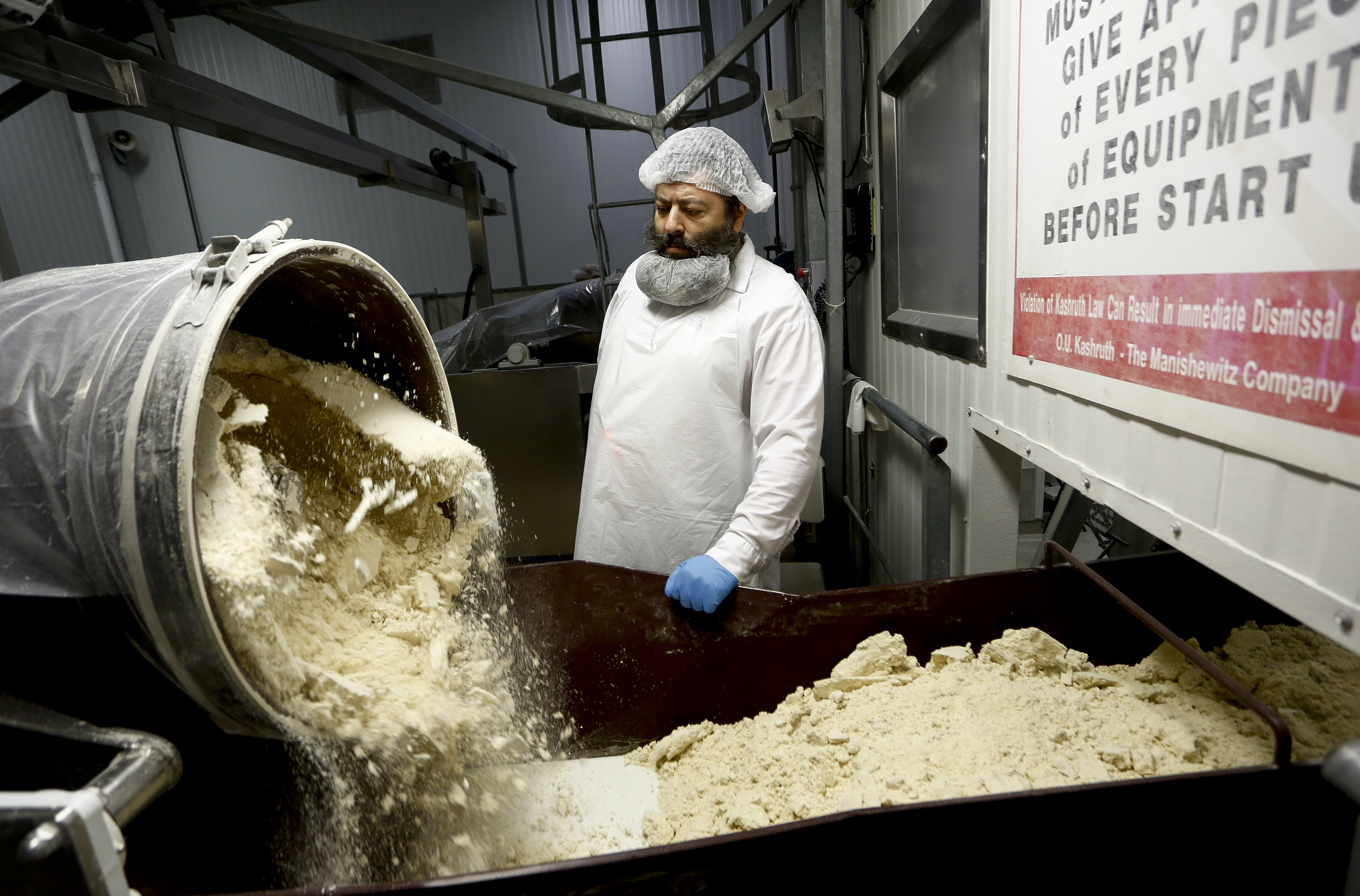 Yehida Kaplovitch, a Mashgiach, or rabbinical supervisor, oversees the mixing of flour on the matzo production line at the Manischewitz manufacturing facility in Newark in 2014.