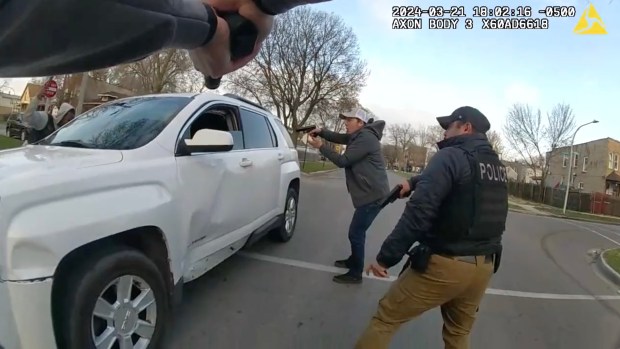 A still image from a video released by the Civilian Office of Police Accountability shows a group of Chicago police officers surrounding a vehicle driven by Dexter Reed, 26, moments before an "exchange of gunfire" in which Reed was fatally shot on March 21, 2024, on the West Side. (Chicago Police Department)