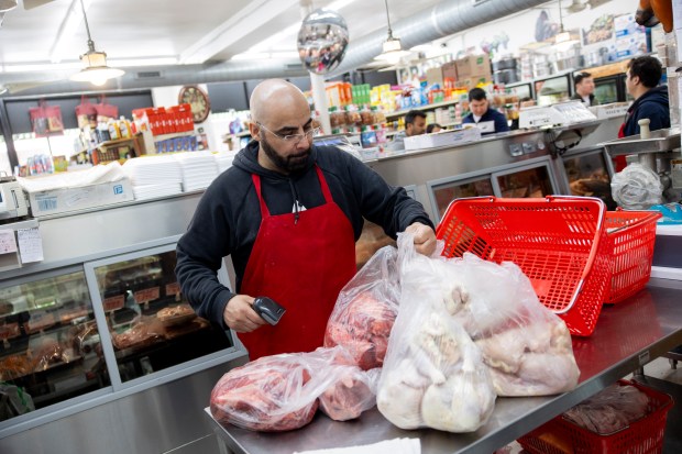 Khaled Manasar bags up meat for a customer's order on April 20, 2024, at Farm City Meat Halal & Grocers in Chicago. (Vincent Alban/Chicago Tribune)