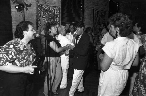 Luis M. Larralde, left, of the Samuel Del Real Orchestra, sings for the crowd at Cairo's dance club on Tropical Tuesday on July 3, 1990, in Chicago. (John Kringas/for the Chicago Tribune) scanned from print, published on July 11, 1990.