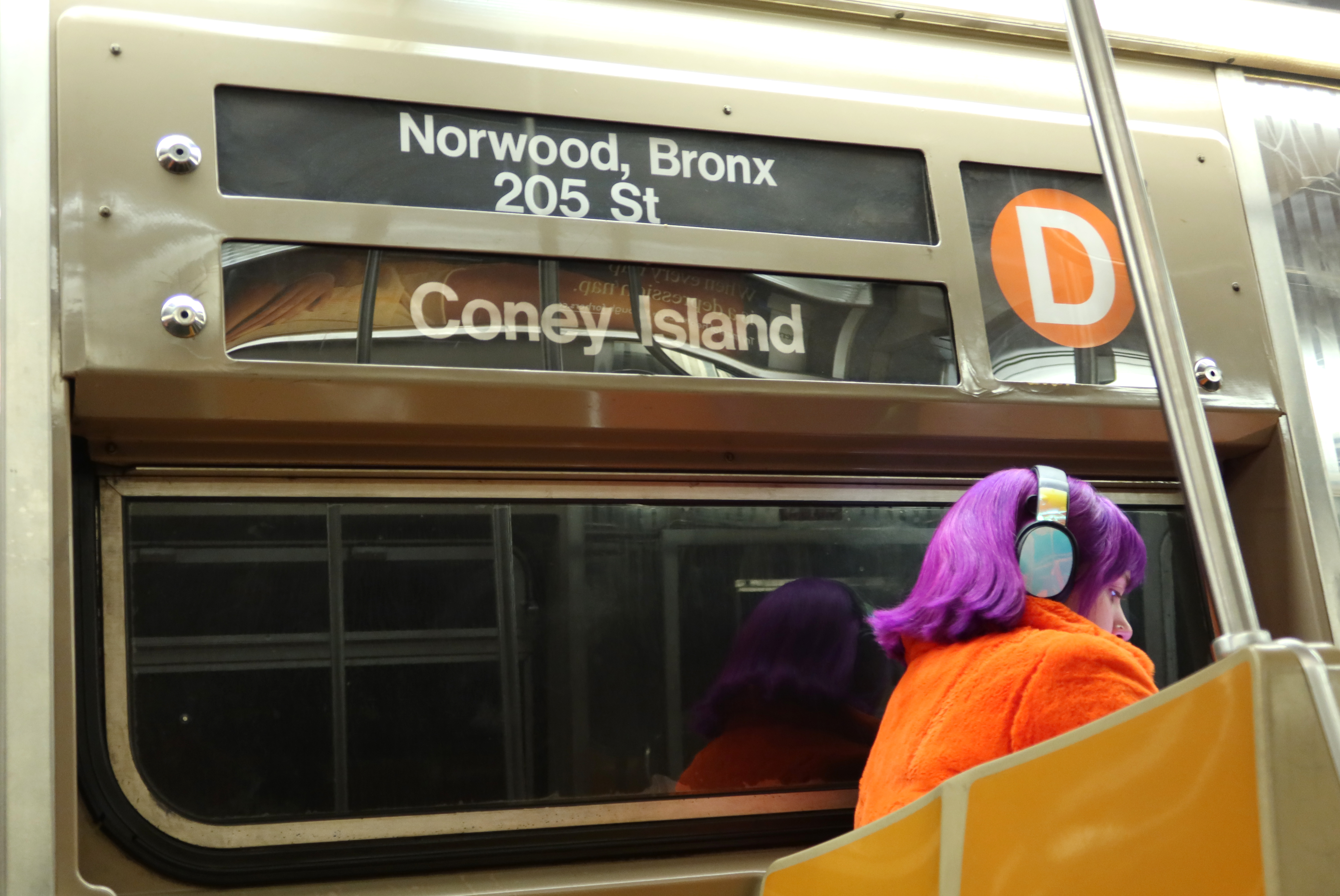 A person sits on the D train