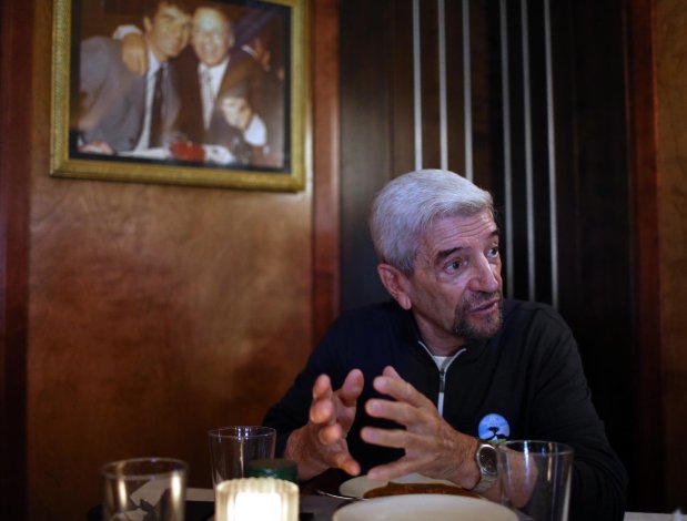Harvey native Tom Dreesen visits the restaurant Gibsons on Rush Street in Chicago in 2019, sitting under a photo of himself with Frank Sinatra. He'll be back in Chicago in May for two programs where he'll share stories of growing up in the south suburbs and working with former Markham and Park Forest resident Tim Reid. (Terrence Antonio James / Chicago Tribune)