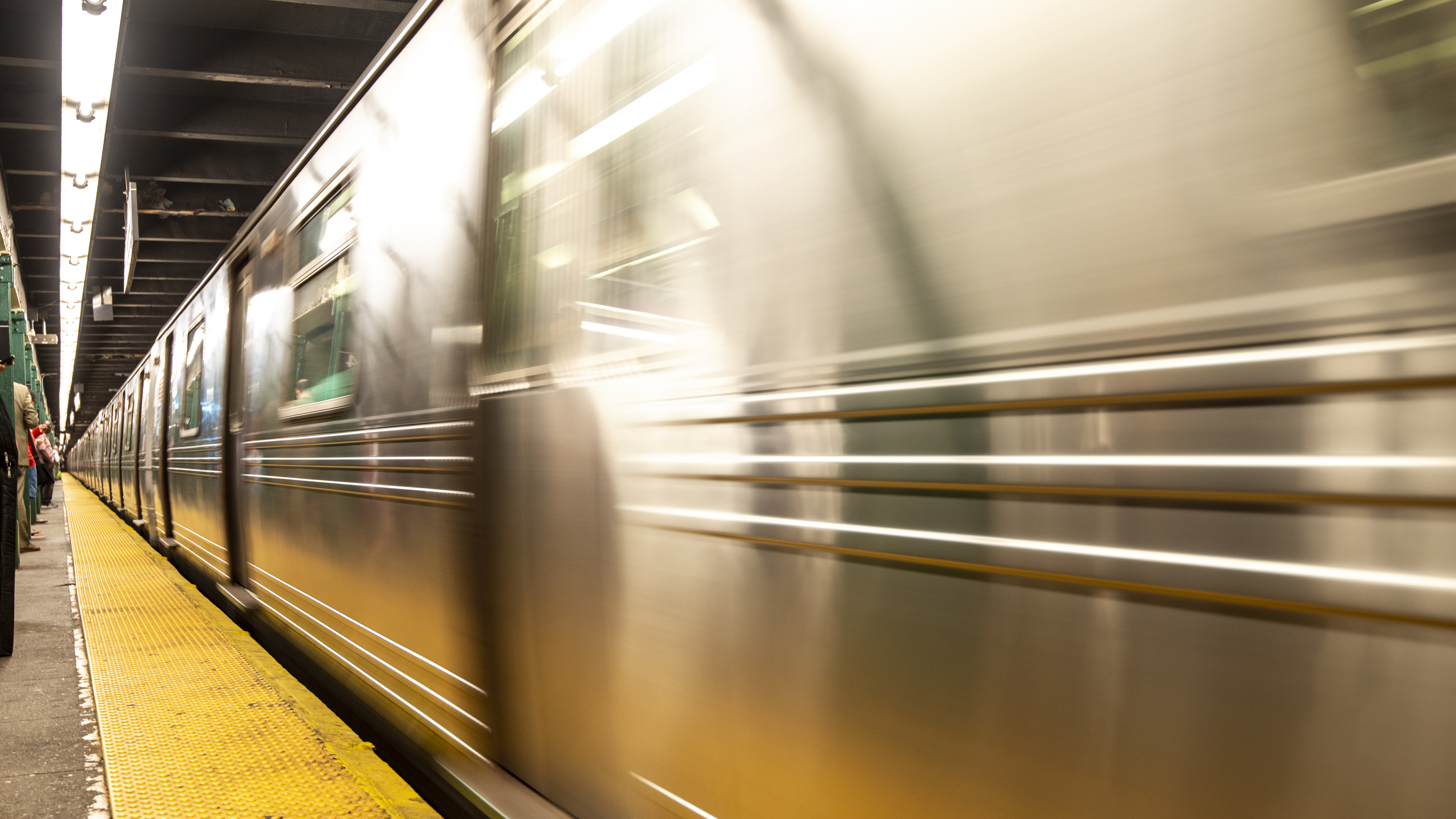 A New York City subway train approaches a station.