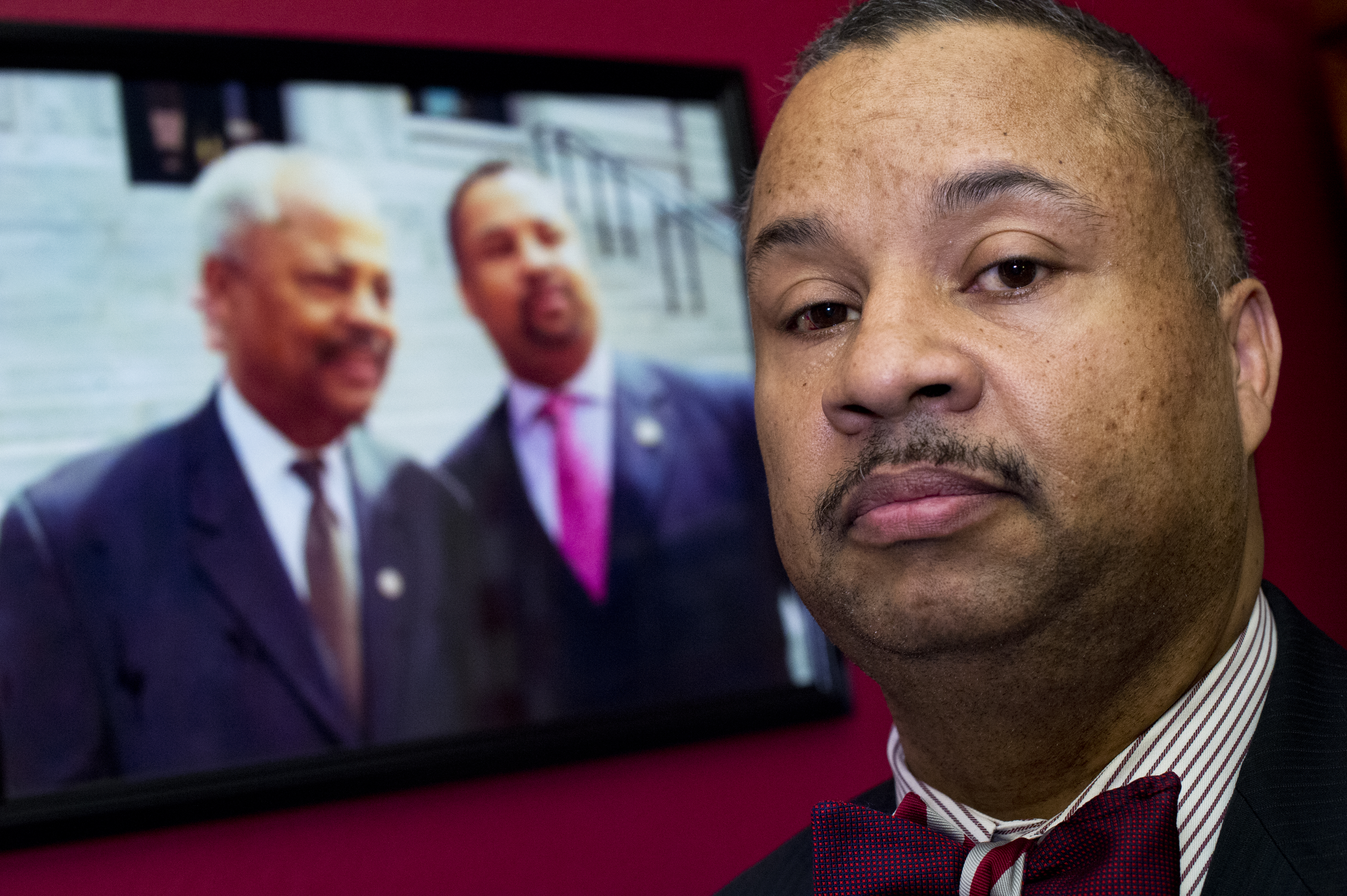 Rep. Donald Payne, Jr in his Cannon Building office near a picture of himself and his late father, former Rep. Donald Payne, in 2016.