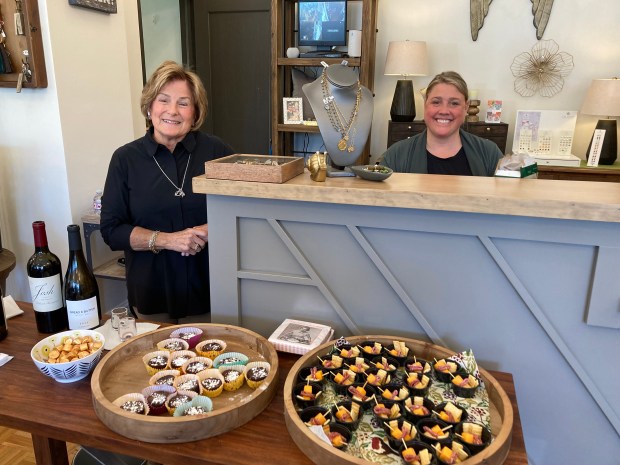 Emily Larson, right, owner of Raffia Boutique on Prospect Avenue in Park Ridge, and her mother Sandra set out snacks for visitors to the Park Ridge Chamber of Commerce's Wine Walk on April 21.