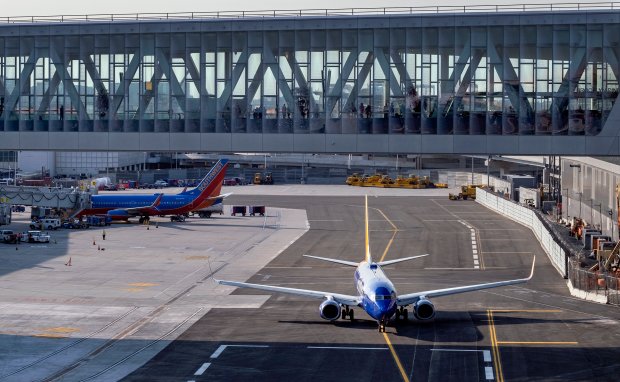 A Southwest aircraft moves along a new taxiway at LaGuardia Airport, May 20, 2021, in New York, becoming the first aircraft to pass beneath the pedestrian sky bridge that connects gates with the new Terminal B at the airport. The sky bridge, one of two, is part of a greater design and redevelopment that will deliver passengers to new gates and reduce gate delays on taxiways that have previously plagued the congested airport. (Craig Ruttle/AP)