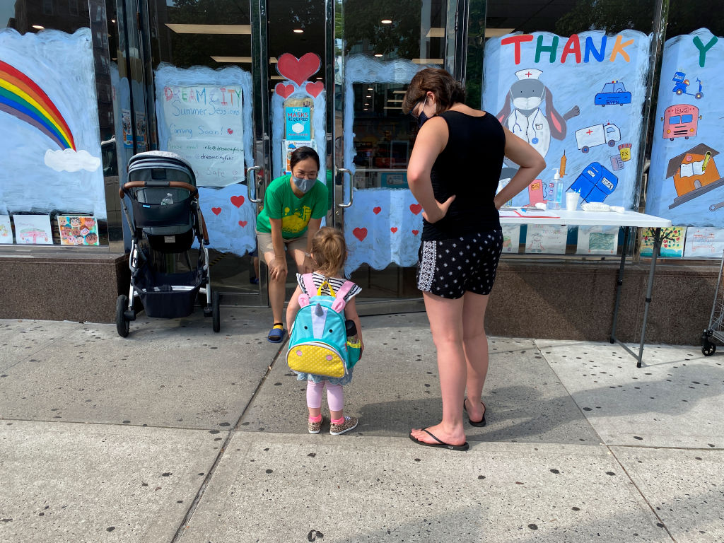 A parent drops off their child at a daycare in Queens.