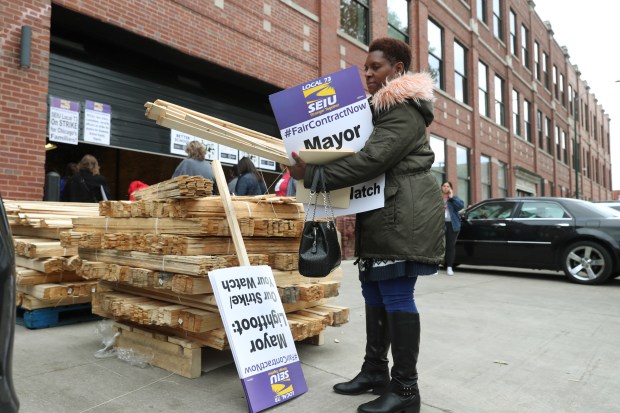 SEIU Local 73 member Tanya Dumas, a special education classroom assistant, picks up picket signs of a pending strike, at the Chicago Teachers Union Center on Oct. 16, 2019, in Chicago. (John J. Kim/Chicago Tribune)