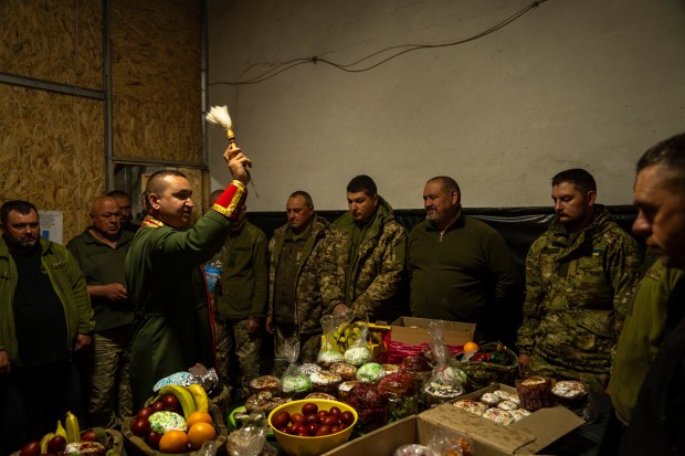 Priest Ivan blesses Ukrainian servicemen of the 72nd Separate Mechanized Brigade, during a Christian Orthodox Easter religious service, in Dnipropetrovsk region, Ukraine, early Sunday, May 5, 2024. (AP Photo/Francisco Seco)