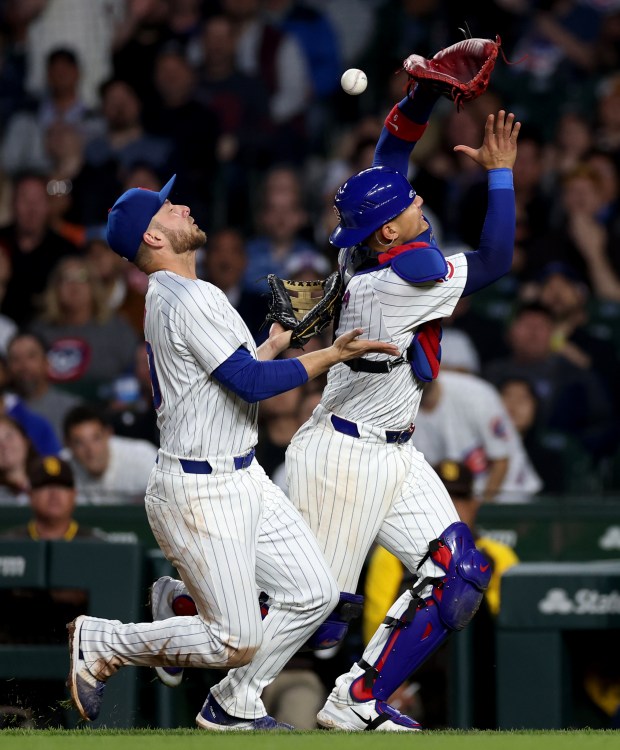 First baseman Michael Busch (left) and catcher Miguel Amaya (right) collide as the two Cubs players are unable to catch a foul ball hit by San Diego Padres designated hitter Manny Machado in the sixth nning of a game at Wrigley Field in Chicago on May 7, 2024. (Chris Sweda/Chicago Tribune)