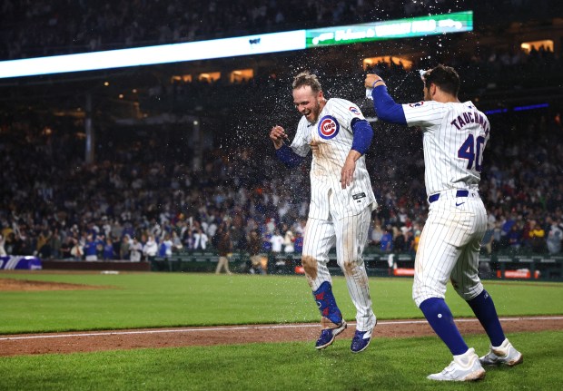 Chicago Cubs first baseman Michael Busch (29) (left) celebrates with teammate Mike Tauchman (40) after Busch hit a walk-off solo home run in the ninth inning of a game against the San Diego Padres at Wrigley Field in Chicago on May 7, 2024. (Chris Sweda/Chicago Tribune)