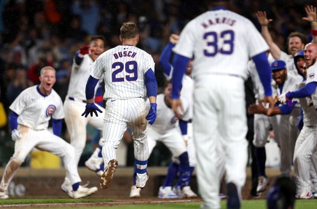 Chicago Cubs first baseman Michael Busch (29) is greeted at home plate after hitting a walk-off solo home run in the ninth inning of a game against the San Diego Padres at Wrigley Field in Chicago on May 7, 2024. (Chris Sweda/Chicago Tribune)