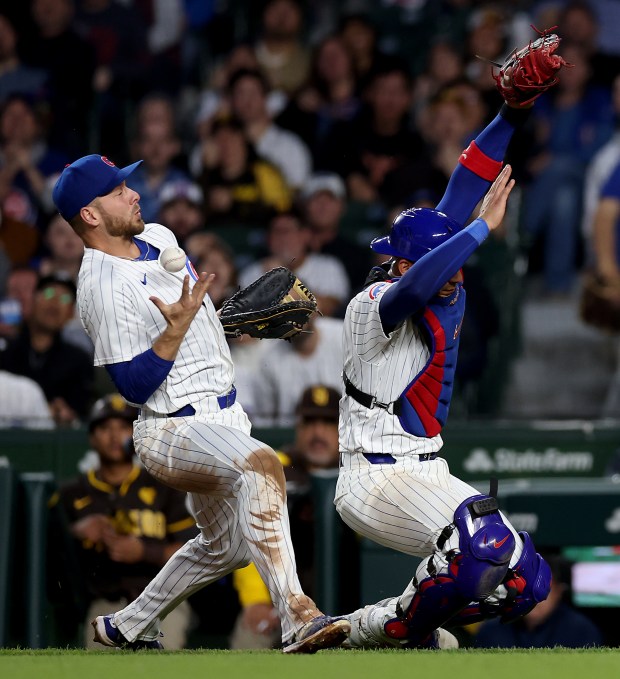 First baseman Michael Busch (left) and catcher Miguel Amaya (right) collide as the two Cubs players are unable to catch a foul ball hit by San Diego Padres designated hitter Manny Machado in the sixth nning of a game at Wrigley Field in Chicago on May 7, 2024. (Chris Sweda/Chicago Tribune)