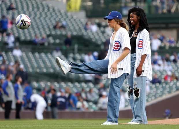 Chicago Red Stars players Cari Roccaro (left) and Jameese Joseph kick a soccer ball as the ceremonial first kick before a baseball game between the Chicago Cubs and the San Diego Padres at Wrigley Field in Chicago on May 7, 2024. (Chris Sweda/Chicago Tribune)
