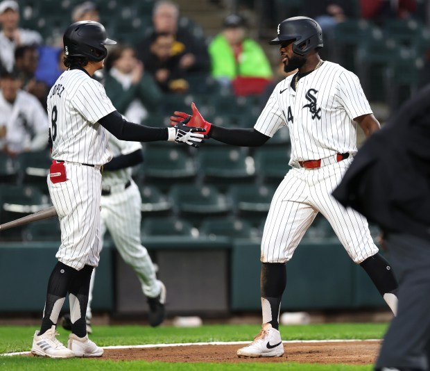 White Sox third baseman Bryan Ramos, right, is congratulated by teammate Nicky Lopez after scoring in the second inning against the Guardians on May 9, 2024, at Guaranteed Rate Field. (Chris Sweda/Chicago Tribune)