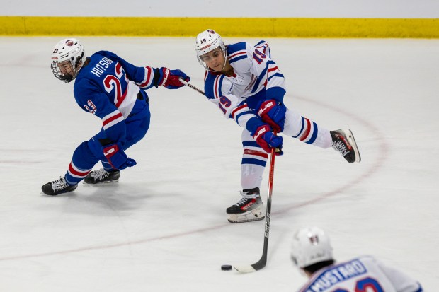 Michael Hage attempts to make an acrobatic pass while being checked by Cole Hutson during Chipotle All-American Game between Team Blue and Team White at USA Hockey Arena on Jan. 15, 2024 in Plymouth, Mich. (Michael Miller/ISI Photos)