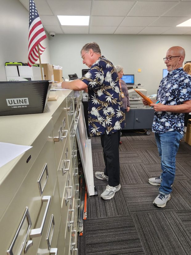 Election Board Member Jeff Chidester signs documents for certification of the 2024 primary while Board President Paul Rausch looks on during a board meeting on Friday, May 17, 2024. (Shelley Jones/for Post-Tribune)