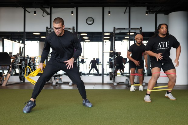 Athletes They Fear founder Kofi Hughes, left, puts Simeon players Mikeshun Beeler, right, and Chris Burgess Jr. through a workout on April 10, 2024, in Chicago. (John J. Kim/Chicago Tribune)