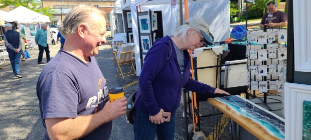 Jenny and John Lambrecht of St. Charles check out a handmade table in May at the annual St. Charles Fine Art Show. Applications are now available for artists who want to take part in next year's show.