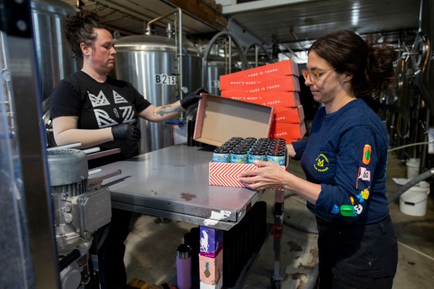 Shanna Trecker, left, and Briana Hestad package cans seltzer with THC on May 22, 2024, at Marz Community Brewing Co. (Vincent Alban/Chicago Tribune)