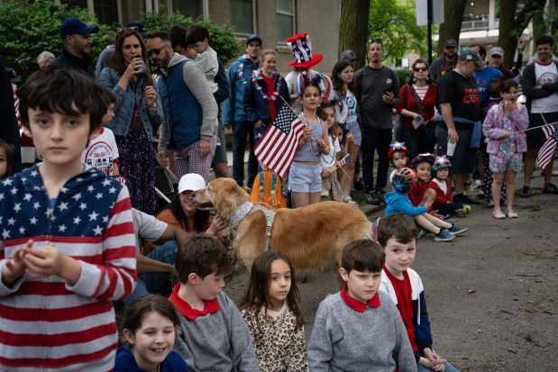 The crowd watches the Jesse White Tumblers during the annual WOOGMS, Wellington-Oakdale Old Glory Marching Society, Memorial Day Parade in the Lakeview neighborhood on May 27, 2024. The neighborhood parade has been a tradition since 1963. (E. Jason Wambsgans/Chicago Tribune)