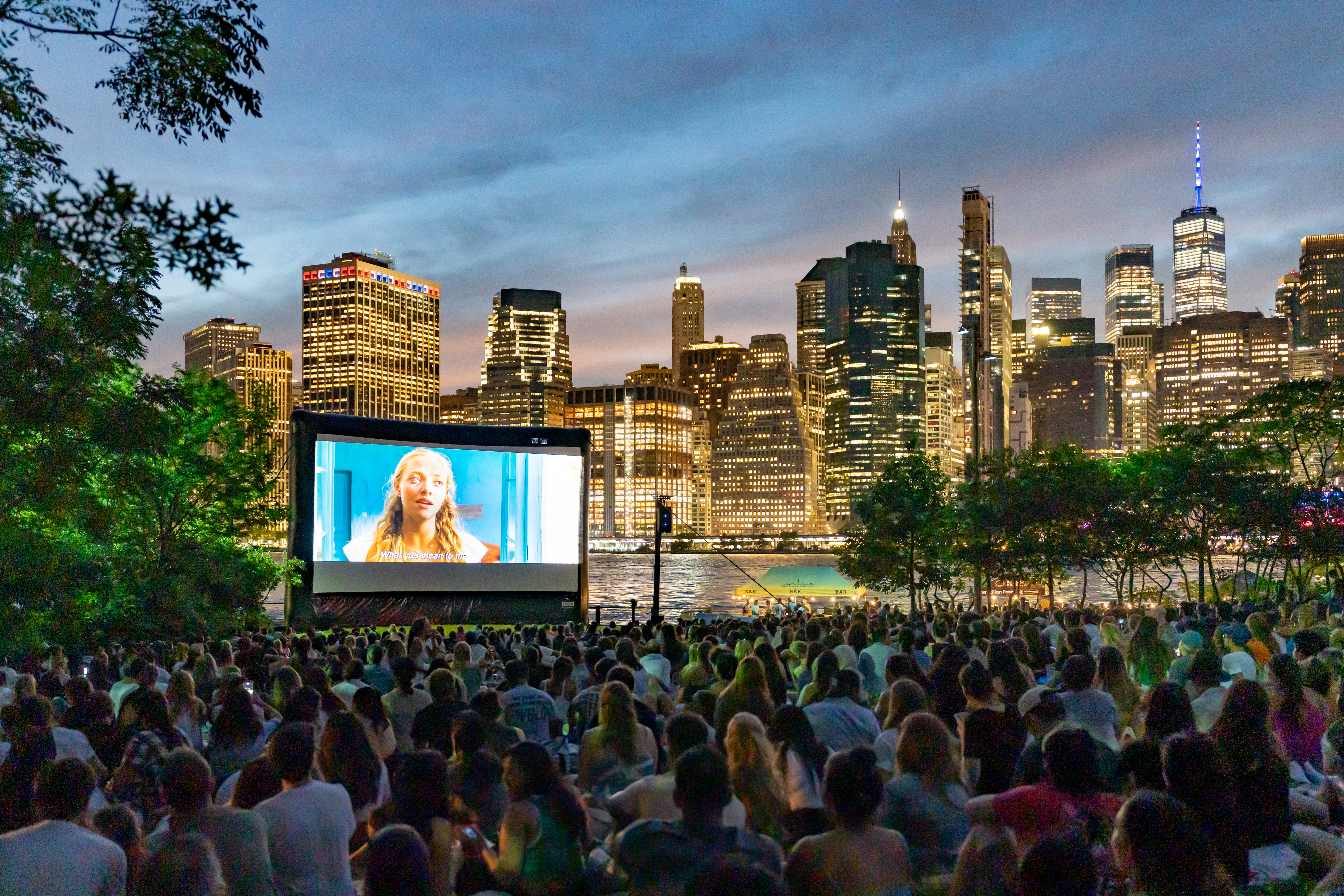 A group of people watch a movie outside.