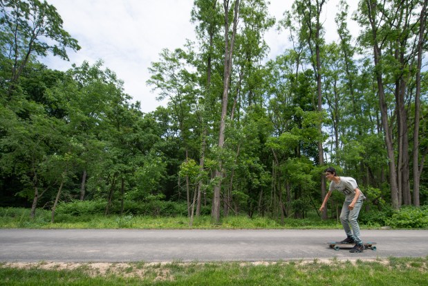 Highland, Indiana resident DJ Lopez takes his skateboard down the Burns Harbor leg of the Marquette Greenway Trail shortly after a celebration of its opening on, June 4, 2021. (Kyle Telechan/for the Chicago Tribune)