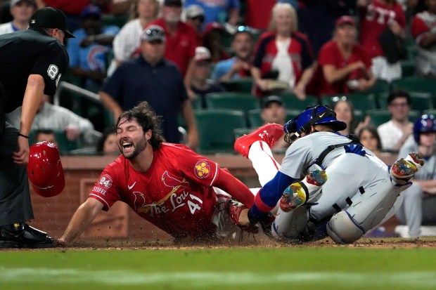 St. Louis Cardinals' Alec Burleson, left, scores past Chicago Cubs catcher Miguel Amaya during the eighth inning of a baseball game Saturday, May 25, 2024, in St. Louis. (AP Photo/Jeff Roberson)