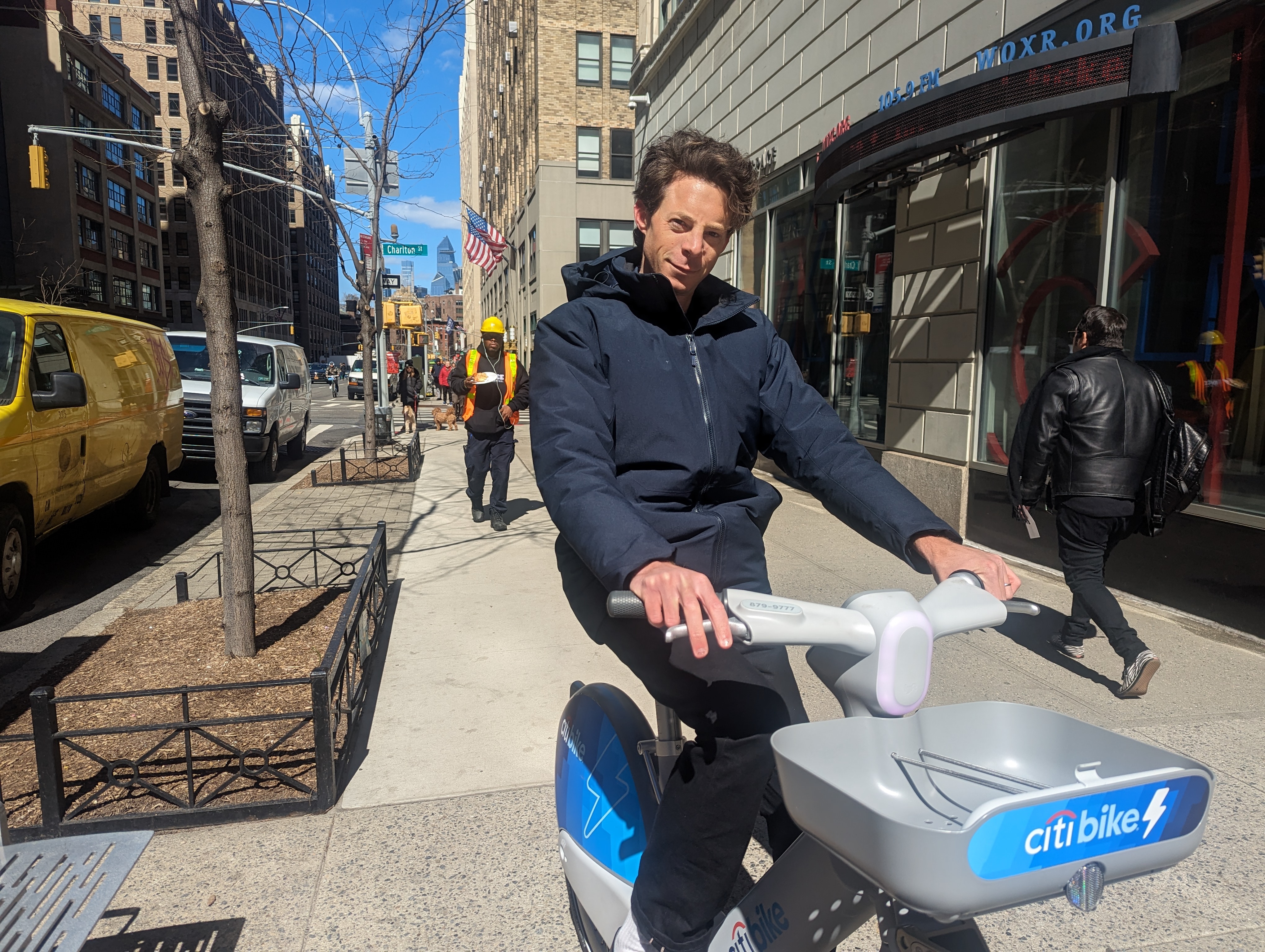 James Ramsay riding an e-bike on the sidewalk