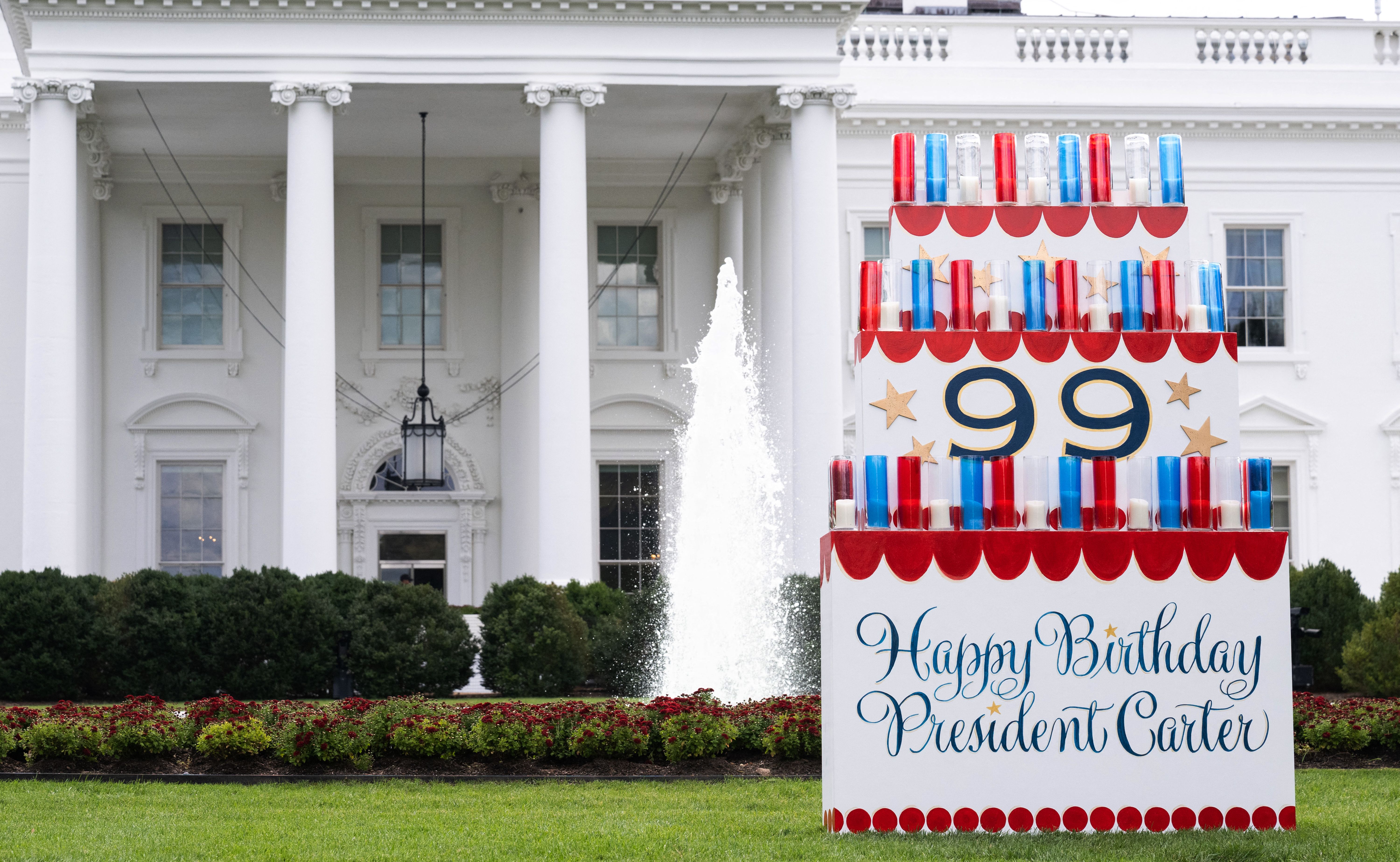 a birthday cake sign honoring Jimmy Carter at 99